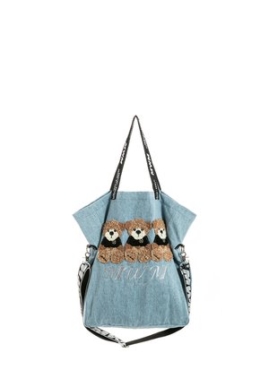 Bolsa tote azul claro con tres ositos de peluche marrones que llevan camisetas negras bordadas en el frente, con correas para el hombro en blanco y negro.