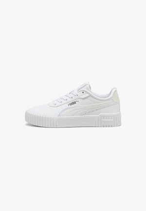 Sneaker bianco con tomaia in sintetico liscio, lacci piatti, suola in gomma più spessa e logo del marchio in evidenza sul lato. Dettaglio di cuciture a contrasto.