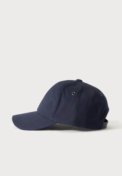 Casquette de baseball bleu marine avec une visière courbée et des œillets de ventilation en métal sur les côtés, présentée sur un fond clair uni.