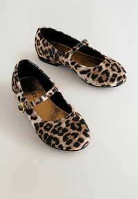 Chaussures ballerines à imprimé léopard avec un bout arrondi, une sangle à travers le cou-de-pied, en matière synthétique style fourrure, et un petit talon bloc. Détail de bouton doré.