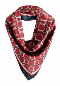 Foulard in seta con un motivo geometrico rosso e beige, piegato a forma di triangolo con un bordo blu scuro. Texture morbida e colori vivaci.