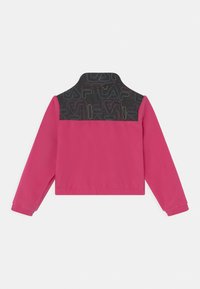 Giacca rosa con maniche lunghe, caratterizzata da un retro superiore a motivo nero e colletto. Tessuto liscio, design corto.