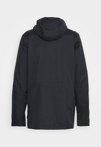 Zwarte waterdichte jas met capuchon, voorzien van een gestructureerd oppervlak en versterkte stiksels, ontworpen voor buitengebruik.