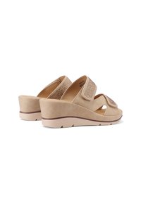 Infradito beige con zeppa, dotate di due cinturini regolabili, realizzate in morbido suede, con punta aperta e parte superiore testurizzata decorata con dettagli.