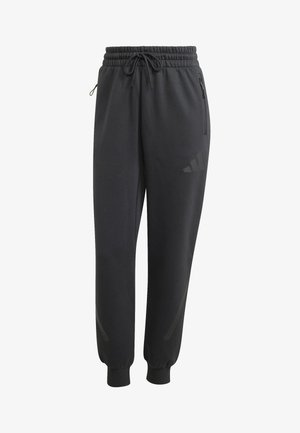 Black athletic pants with a drawstring waist, side zip pockets, and tapered cuffs. Features a subtle logo in coordinating color on the thigh.