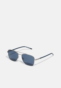 Ochelari de soare cu un cadru metalic argintiu, lentile cu nuanță albastră, formă rectangulară și brațe albastre cu detalii ale logo-ului mărcii.