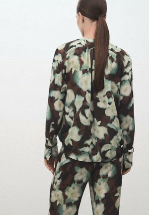 Blusa con estampado floral y pantalones a juego en tonos marrón oscuro, verde y blanco; tejido transparente con un corte relajado y detalles de botones en las mangas.