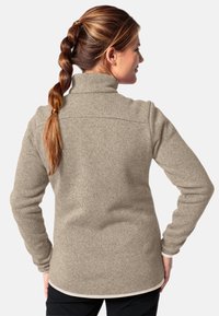 Pullover in felpa beige con colletto alto, tessuto texturizzato e maniche lunghe. Presenta un orlo dritto e un sottile profilo in contrasto sul fondo.