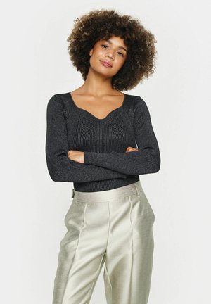 Zwarte geribbelde lange mouw top met een sweetheart decolleté, gecombineerd met lichte metallic zilveren wijde broek. Soepele textuur en aansluitend design.