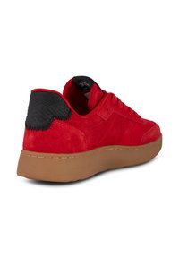 Crvene nubuk tenisice s teksturiranim crnim kožnim naglaskom na peti i gumenim potplatom. Imaju šivane detalje i istaknuti brend tag.