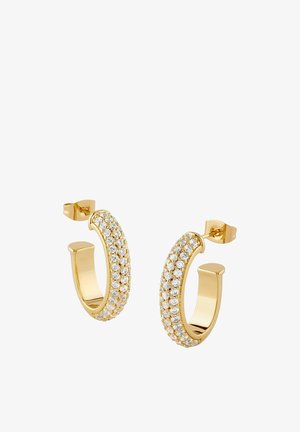 Para złotych kolczyków-koła z trzema rzędami małych, przezroczystych kamieni szlachetnych i zapięciem na sztyft na białym tle.