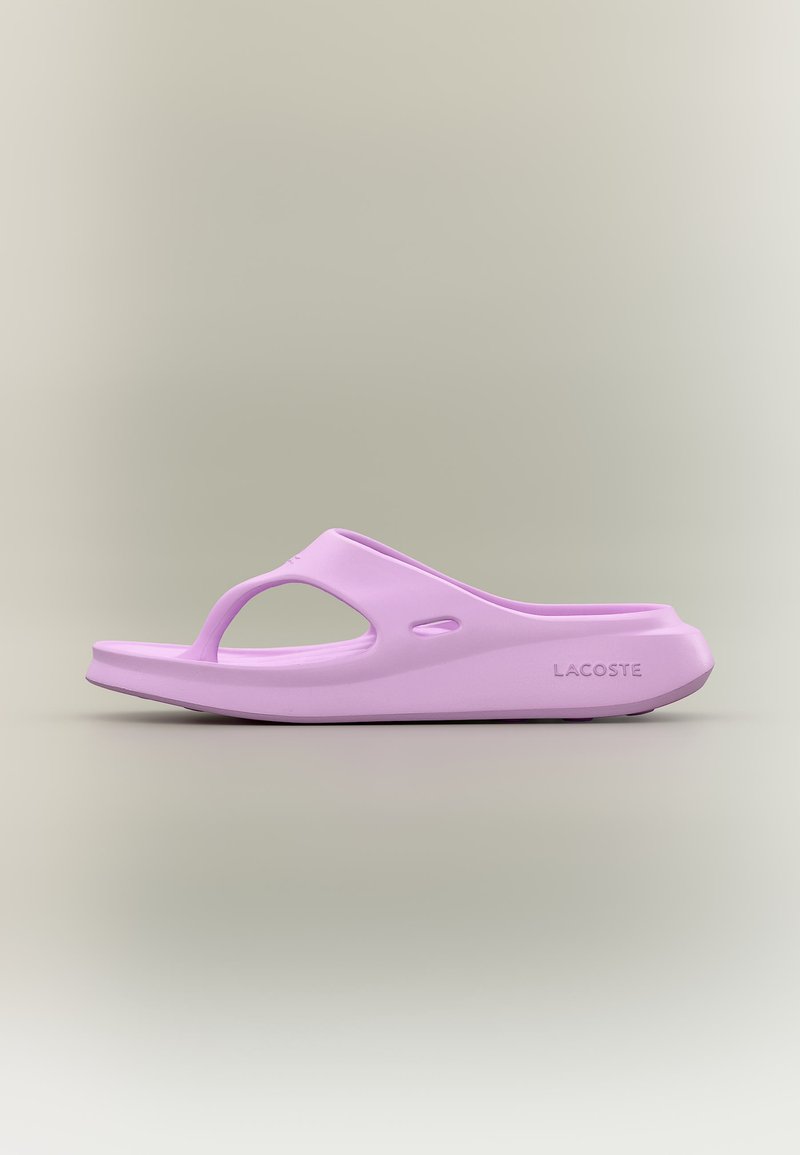 Ανοιχτό μωβ σανδάλι Lacoste με ανοιχτό δάχτυλο, παχιά σόλα και λογότυπο στο πλάι σε ουδέτερο φόντο.