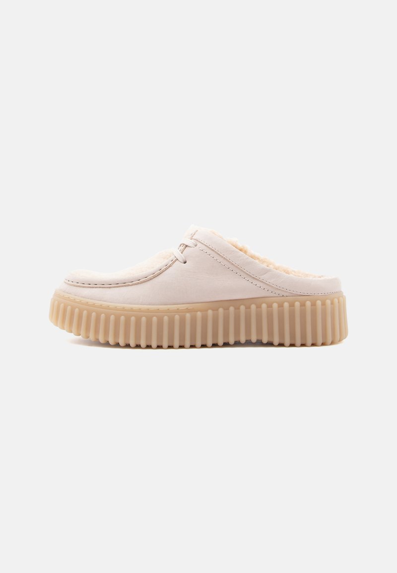Lys beige slip-on sko med myk fôr, rund tå og ribbet beige gummisåle. Glatt overmateriale og subtile sømdetaljer.