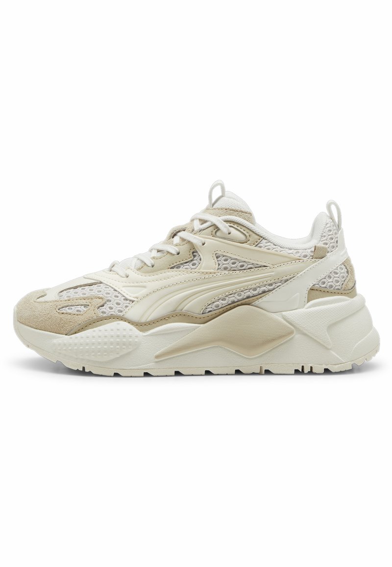 Zapatillas beige y crema con una parte superior de malla texturizada, acentos de ante, una suela gruesa y un detalle de logotipo en contraste en el costado.