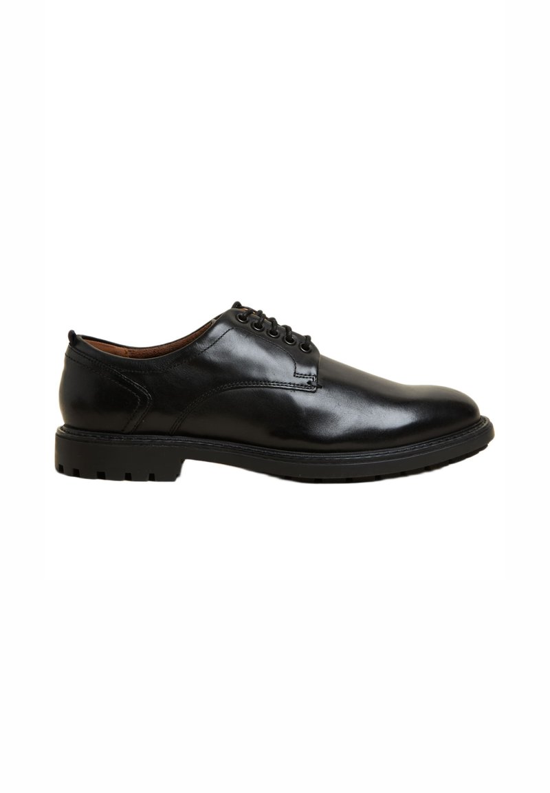 Chaussure en cuir noir avec une texture lisse, bout rond, cinq œillets et une semelle en caoutchouc épaisse avec un motif de traction.