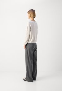 Gray wide-leg trousers paired with a light beige knit sweater. The fabric appears soft, with a relaxed fit and a straight silhouette.