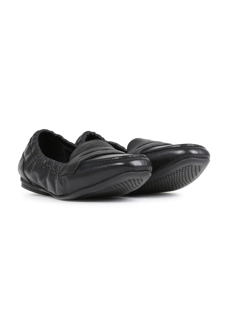 Zwarte instap schoenen van glad leer met een gewatteerd design, ronde neus en een rubberen zool met textuur voor grip.