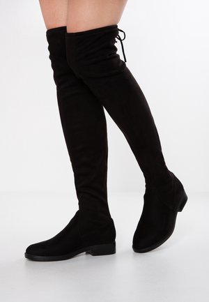 Stivali neri in suede sopra il ginocchio con texture liscia, punta tondeggiante, tacco basso a blocco e dettaglio regolabile con lacci nella parte superiore.