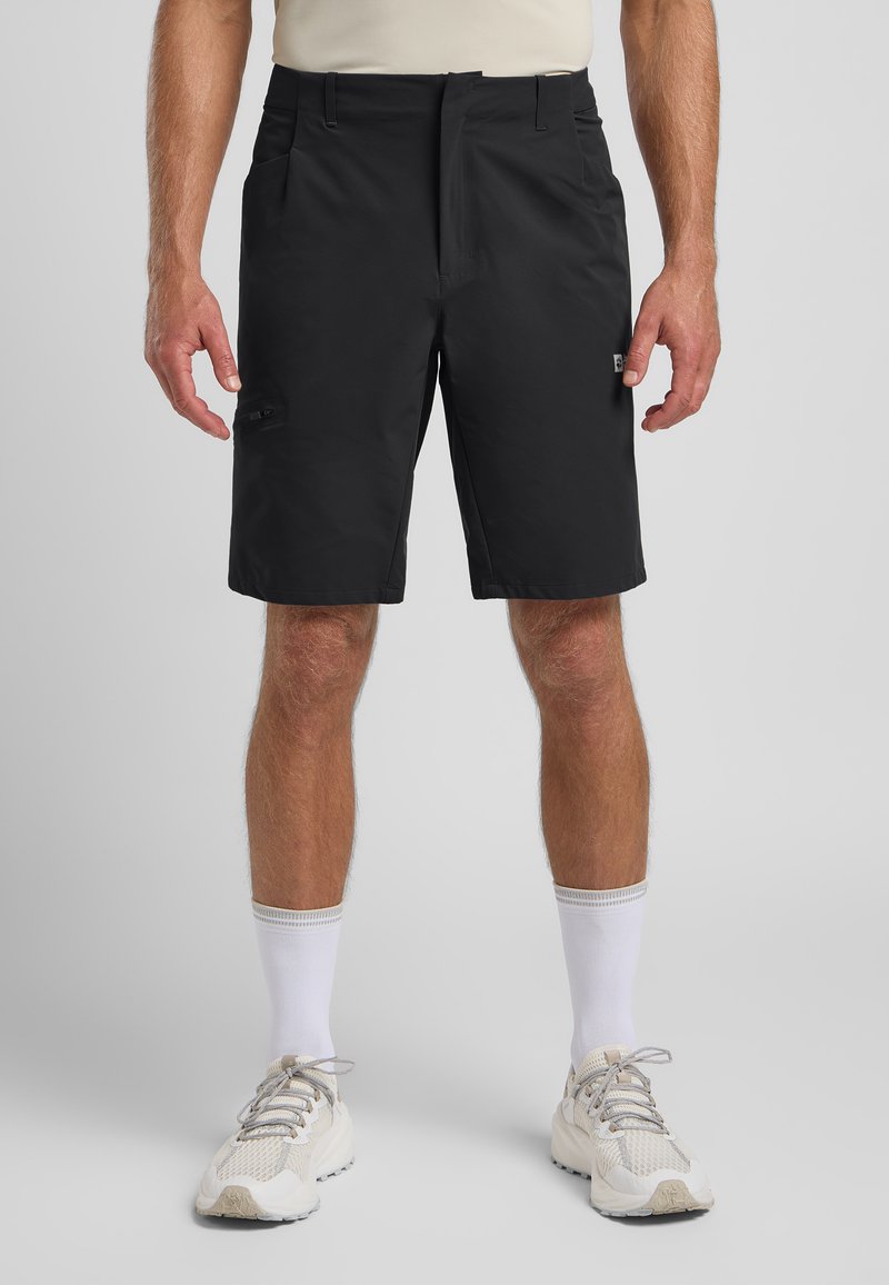Schwarze Shorts aus leichtem Stoff, mit einem Frontreißverschluss, Seitentaschen und einer einzeln mit Reißverschluss versehenen Tasche am Oberschenkel.