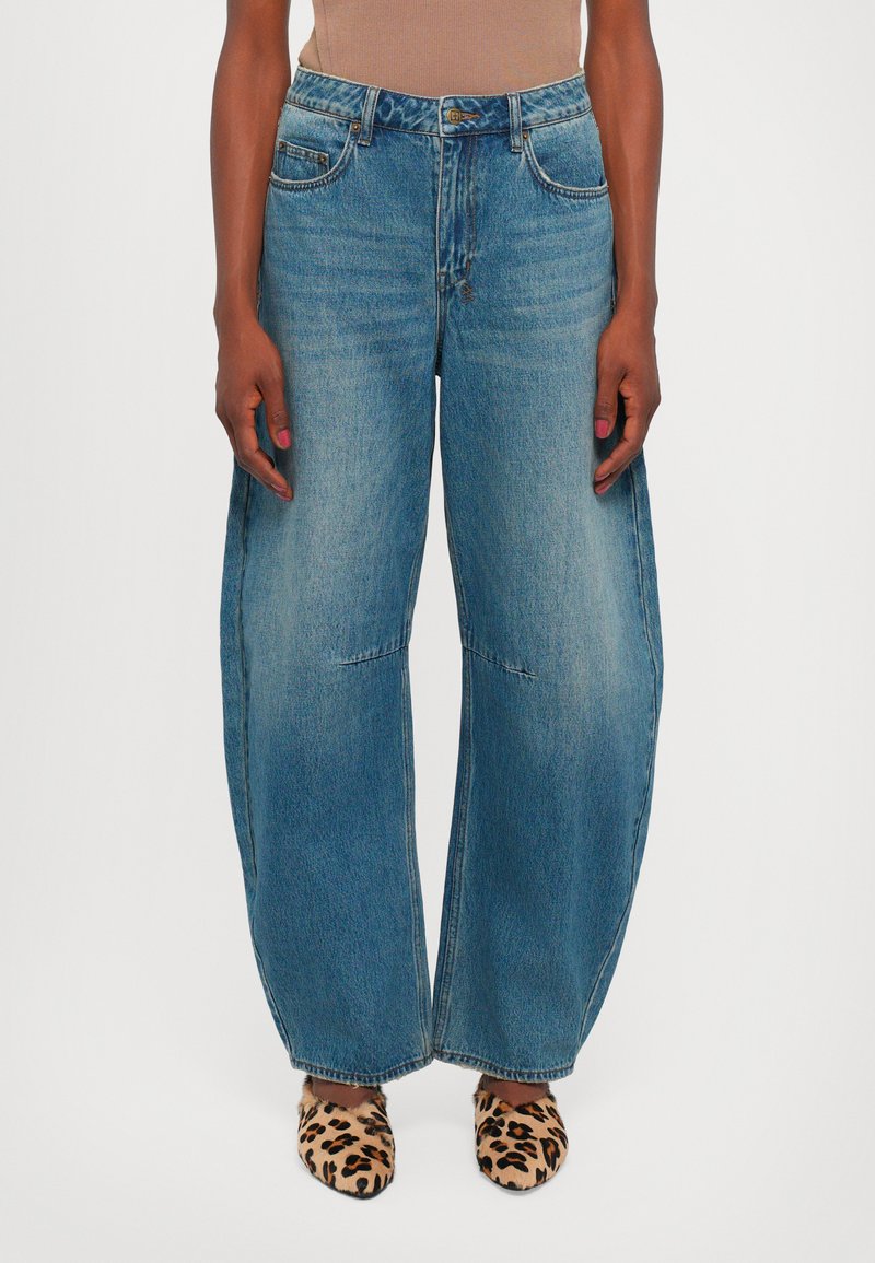 Ljusblå, vida jeans i denim med klassisk femfickdesign och en blekt finish. Matchas med leopardmönstrade skor.