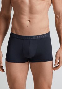 Mörkblå herrboxer i mjukt tyg, med en mjuk elastisk midjeförband med "Intimissimi"-logotyp. Skräddarsydd passform med konturerad fram.