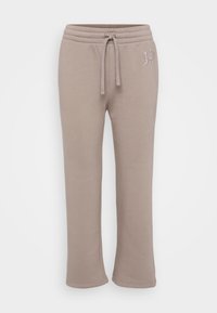 Gai beige joggeri, izgatavoti no mīksta kokvilnas, ar elastīgu jostasvītru un auklu, kā arī nelielu izšuvumu ar logo uz sāna.