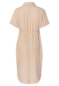 Šaty s krátkým rukávem a límečkem v světle béžové barvě, s upnutým pasem a volnou sukní, vyrobené z jemné, texturované látky.