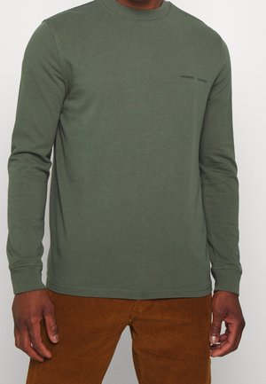Camicia verde a maniche lunghe con scollatura rotonda e polsini a costine, con una piccola stampa del logo nero nella zona sinistra del petto.