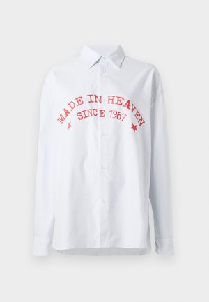 Csíkos, kék és fehér gombos ing, piros felirattal: "MÉG A MENNYBŐL, 1967 ÓTA." Hosszú ujjú, laza szabású, pamut keverék anyagból készült.