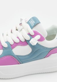 Sneaker with white, blue, and pink leather, featuring thick white laces, cube detail on the side, and a textured sole.