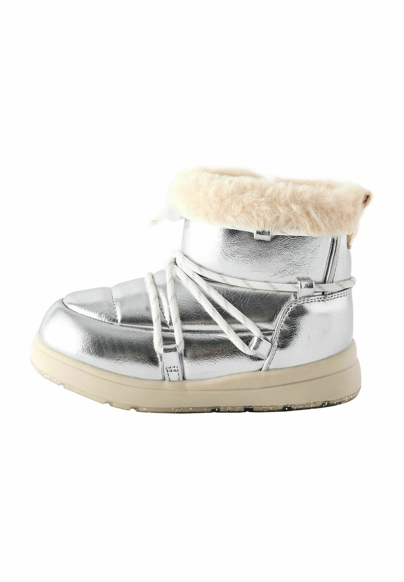 Silver, metallisk ankelsko med en fluffig beige krage, kontrasterande vita snören och en beige gummisula. Slät textur med vadderad design.