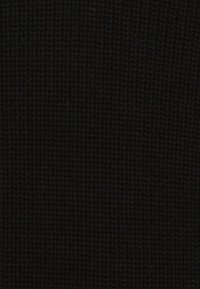 Gestreifte schwarze Strickware mit einer strukturierten, gerippten Oberfläche. Gleichmäßige Farbdarstellung mit einem weichen, flexiblen Aussehen.