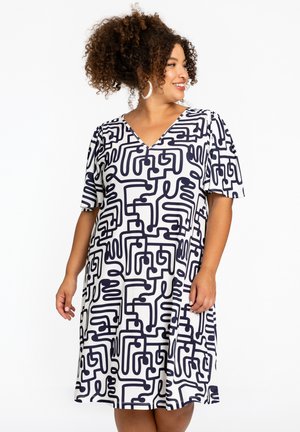 Korte mouw jurk in een witte stof met een gedurfde marineblauwe abstracte print, voorzien van een V-halslijn en een ontspannen pasvorm, die boven de knie komt.
