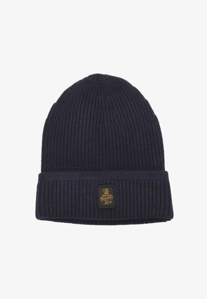 Beanie lavorato a maglia di colore blu navy con una texture a coste, dotato di risvolto e di un'etichetta quadrata con un emblema dorato sul davanti.