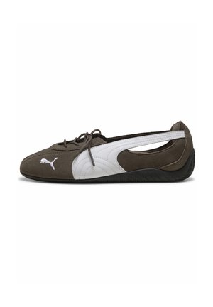 Bruine suède Puma-schoen met witte streep en logo, veters aan de voorkant en uitgesneden hiel, zijaanzicht op een witte achtergrond.