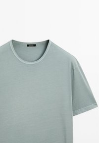 Light blue short-sleeve T-shirt made of soft fabric with a classic crew neckline. Tag visible inside the collar. Flat texture.