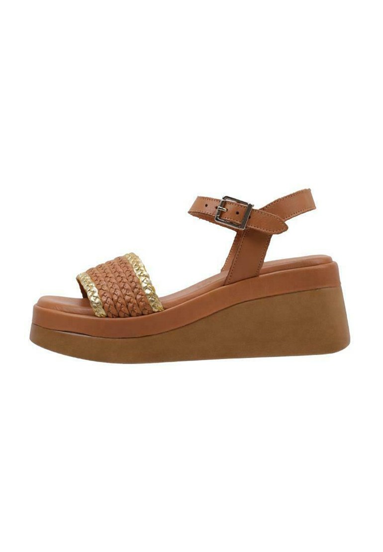 Brown wedge sandal with a woven gold-accented strap. Features a wide platform, adjustable ankle strap, and smooth textured finish.