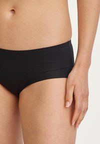 Schwarze Baumwoll-Hipster-Unterwäsche mit glatter Textur, niedrigem Schnitt und elastischem Bund. Keine sichtbaren Muster oder Hardware-Details.