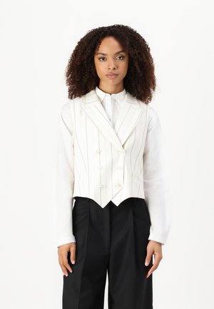 Wit gestreepte gilet met dubbelzijdige knopen, gecombineerd met een wit overhemd en zwarte broek. Stof lijkt tekstuur te hebben, getailleerde pasvorm.