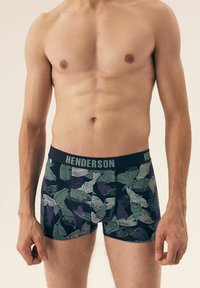 Bokserki na ciemnym tle z wzorem liści w zieleni i purpurze. Pas został oznaczony napisem "HENDERSON" w szarości.