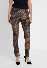 Pantaloni scuri a slim fit con motivo floreale, dotati di tasche con cuciture decorative e una leggera lucentezza.