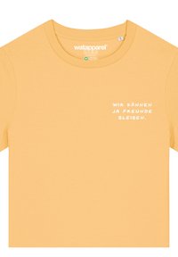 Geel katoenen T-shirt met een ronde hals. Voorzien van witte tekst "WIR KÖNNEN JA FREUNDE BLEIBEN." op de voorkant. Zachte textuur, casual ontwerp.