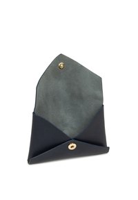 Borsetta in pelle blu navy di forma triangolare, con interno in suede grigio e chiusura a scatto dorata. Esterno con texture.