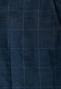 Marineblauer Stoff mit einem subtilen Rautenmuster in blauen Linien und einer strukturierten Oberfläche, die auf ein gewebtes Material hinweist.