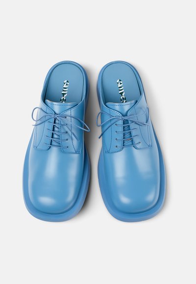 Scarpe blu stringate con una finitura liscia e lucida, punta arrotondata e design minimalista. Sottopiedi testurizzati con un motivo geometrico visibile.
