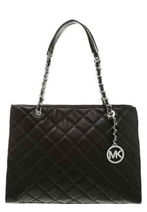 Black quilted leather handbag with silver chain straps and round silver "MK" logo charm hanging on side.