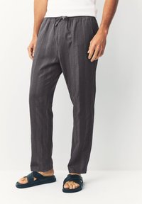 Gray patterned pants with elastic waistband and drawstring. Made of lightweight fabric, featuring a relaxed fit and straight legs.