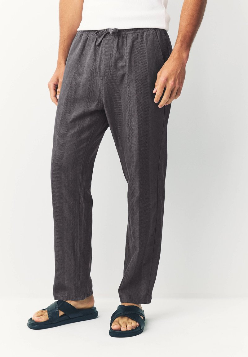 Gray patterned pants with elastic waistband and drawstring. Made of lightweight fabric, featuring a relaxed fit and straight legs.