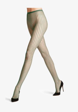 Beneden benen met groene visnetpanty's met een patroon en zwarte hoge hakken, staand tegen een witte achtergrond.