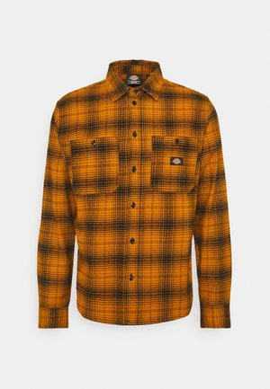 Langärmliges orange-schwarz kariertes Hemd mit schwarzen Knöpfen und zwei vorderen Brusttaschen, eine mit kleinem Logo-Patch.